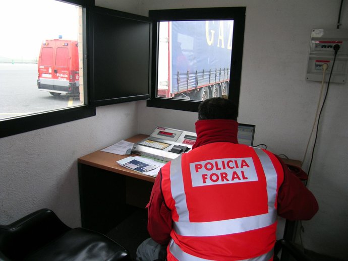 Un agente atiende un control de camiones. 