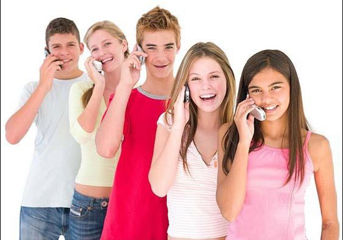 Adolescentes hablan por su teléfono móvil.