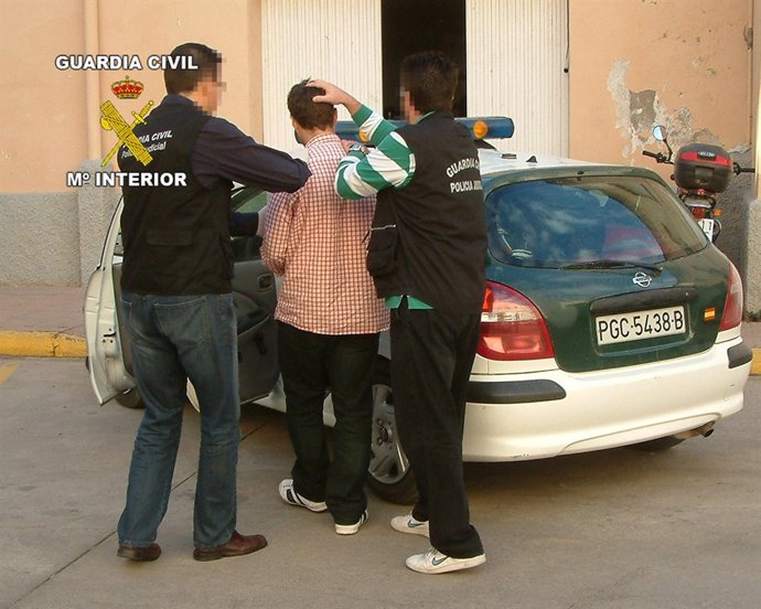 El detenido es introducido en el vehículo policial