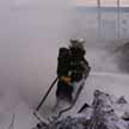 Un bombero apagando el fuego de la residencia