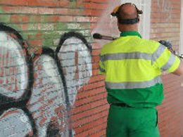 Un empleado municipal borrando grafitis