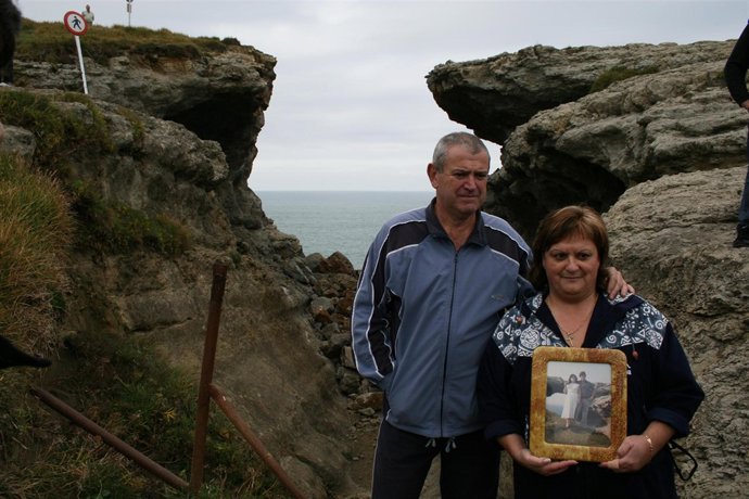 Pareja que muestra una foto del puente original, con el derrumbado de fondo. 