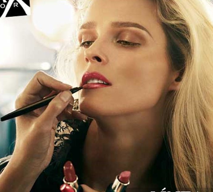Modelo de Max Factor maquillándose los labios