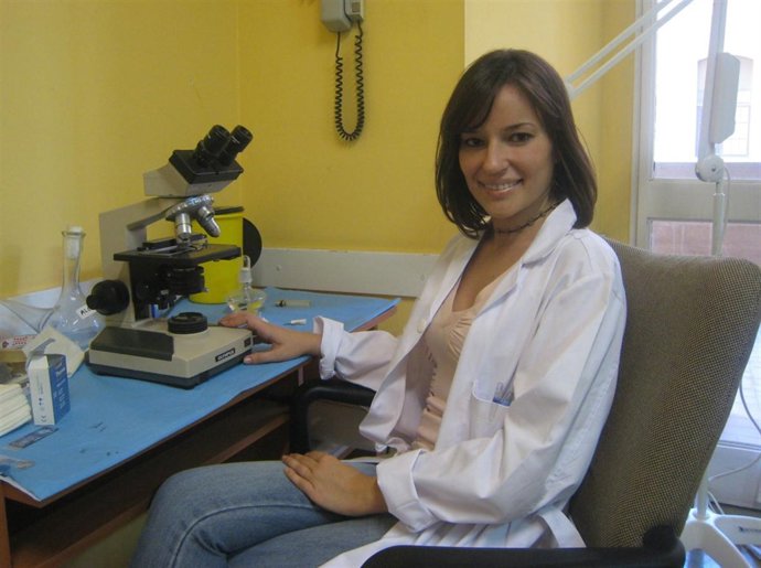 Una médico dermatóloga en su despacho con microscopio