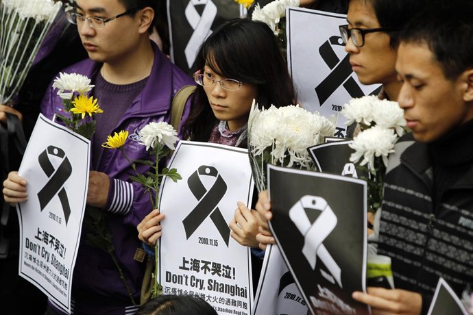 Miles de personas lloran a las víctimas del incendio en el edificio de Shangái