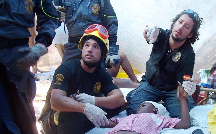 César Claros (sujentando la mano del herido) auxiliando a un niño tras el terrem