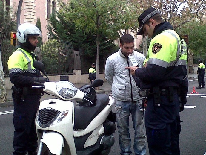 La Guardia Urbana de Barcelona efectuando un control de alcoholemia a un motoris