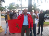 Miembros del 'Comité de Liberación Melilla' despliegan una bandera de Marruecos ante la Delegación antes de huir