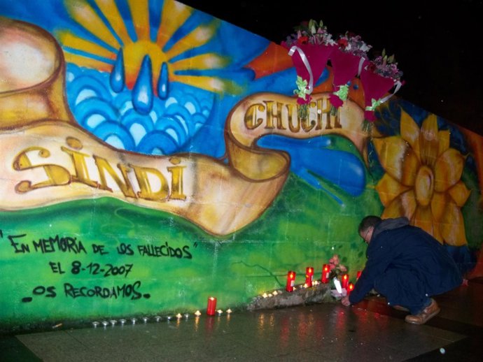 El hijo de una de las víctimas enciende una vela. 