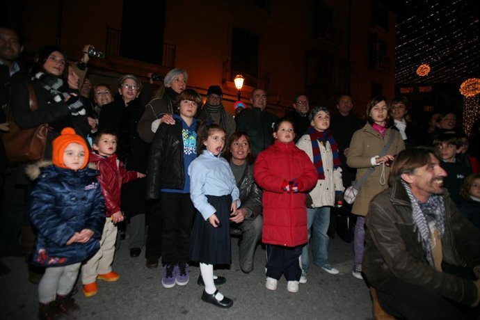 La presidenta del Consell, Francina Armengol, junto a un niño del coro cantando 