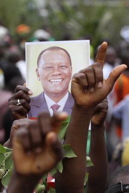 Ciudadano muestra una imagen de Alassane Ouattara, presidente legítimo de Costa 