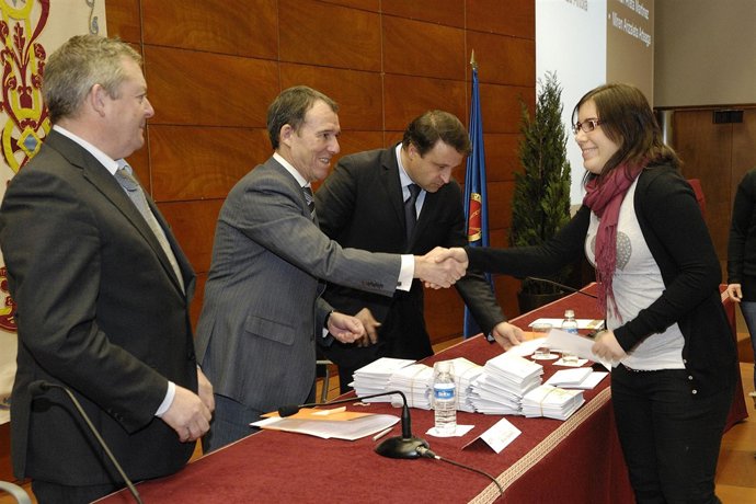 Una estudiante recoge su cheque de manos del rector, Julio Lafuente.