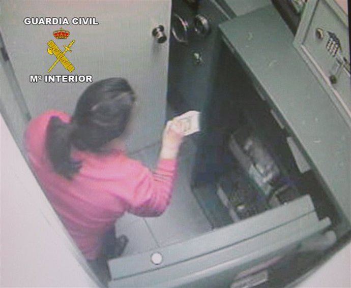La detenida con un fajo de billetes después de meter presuntamente la mano en la