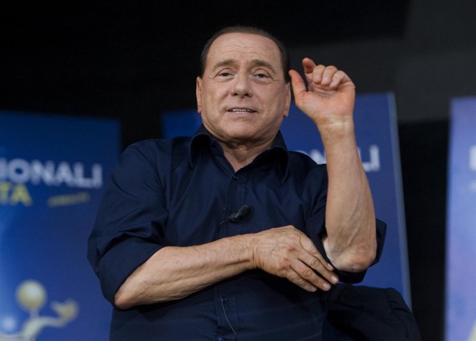 Silvio Berlusconi se atusa la camisa