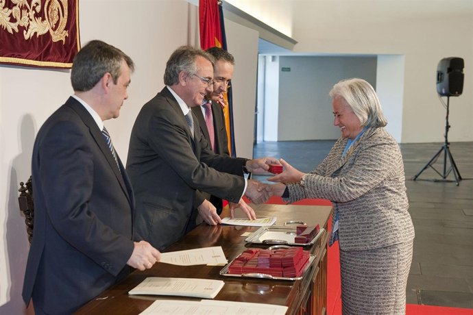 El presidente Sanz entrega el escudo de Navarra a una de las trabajadoras homena