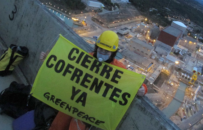 Un activista de Greenpeace muestra una pancarta en una torre de la central nucle