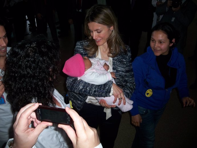 La princesa de Asturias toma en brazos a un bebe en Cartagena, durante la inaugu