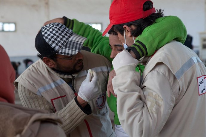 Voluntarios de Media Luna Roja atendiendo a refugiado egipcio