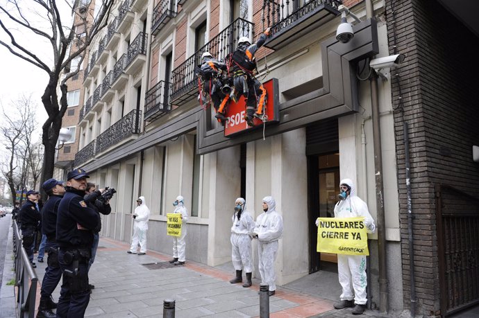 Activistas de Greenpeace sustityen el logo de la sede principal del PSOE para pe