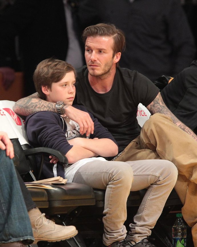 David Bechkam junto a su hijo Brooklyn en un partido de la NBA