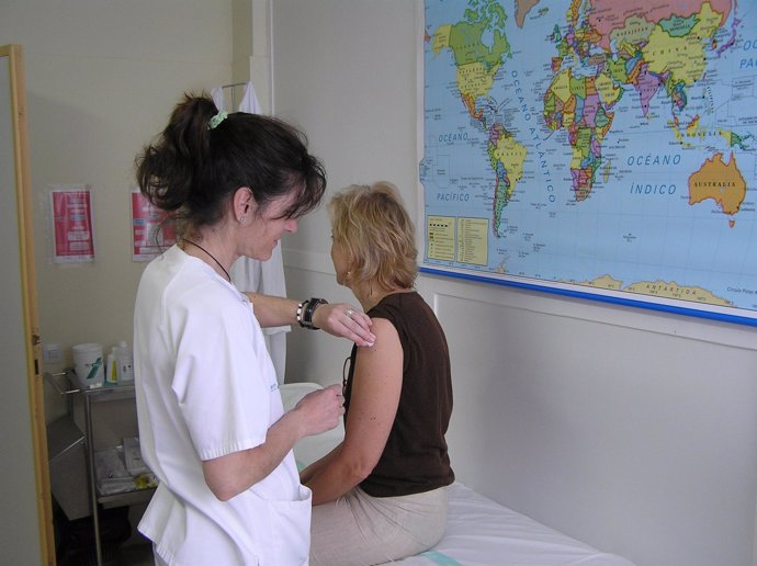 Una enfermera pone una vacuna a una mujer
