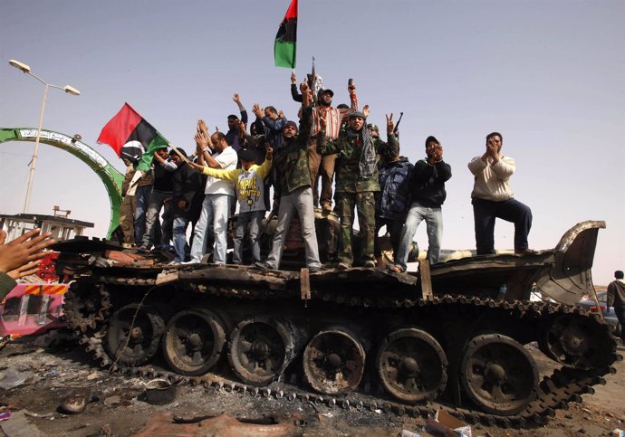 Rebeldes libios sobre los restos de un tanque gadafista