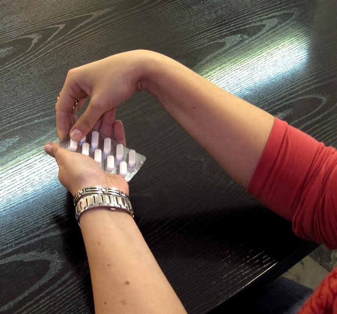 Una joven se toma un antibiótico