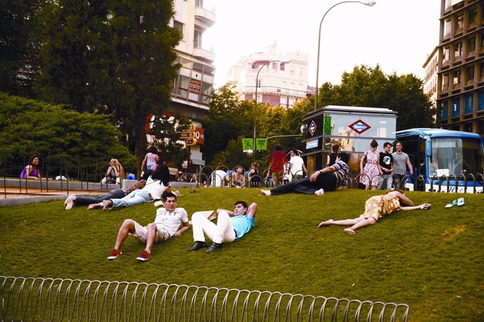 Gente disfrutando del buen tiempo en un parque de Madrid