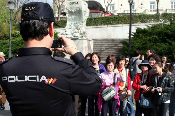 Agente de Policía Nacional atendiendo a turistas japoneses