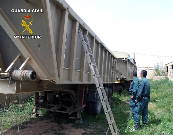 Dos agentes de la Guardia Civil supervisan el cargamento