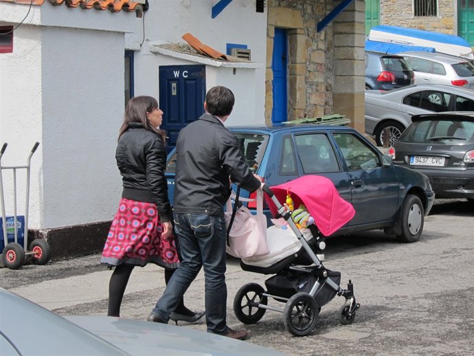 Una pareja pasea a su hijo en un carrito