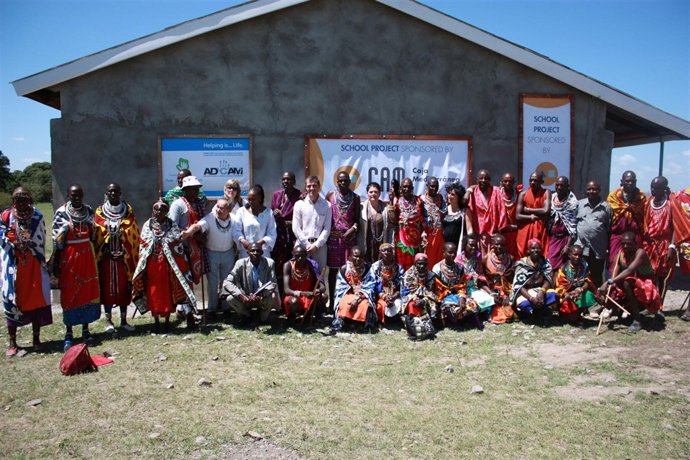 Trabajadores De La CAM Posan Junto Al Colegio Y Los Maasais