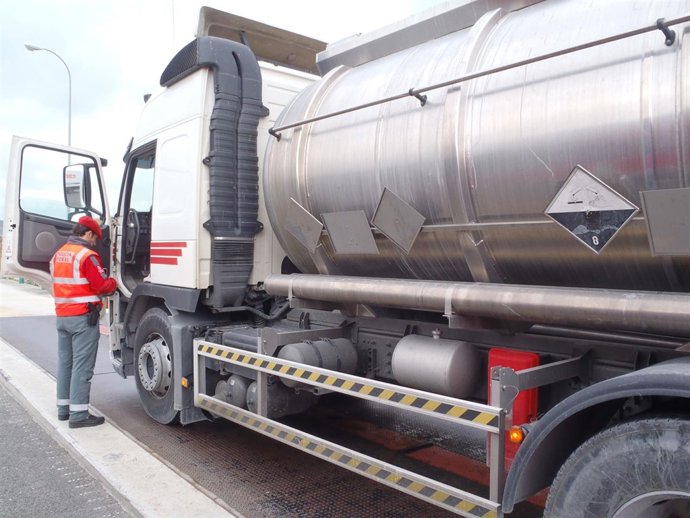 Un Policía Foral Inspecciona Un Vehículo De Transporte De Mercancías Peligrosas.
