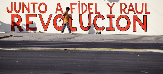 Hombre Paseando Por Cuba Junto A Un Mural A Favor De La Revolución