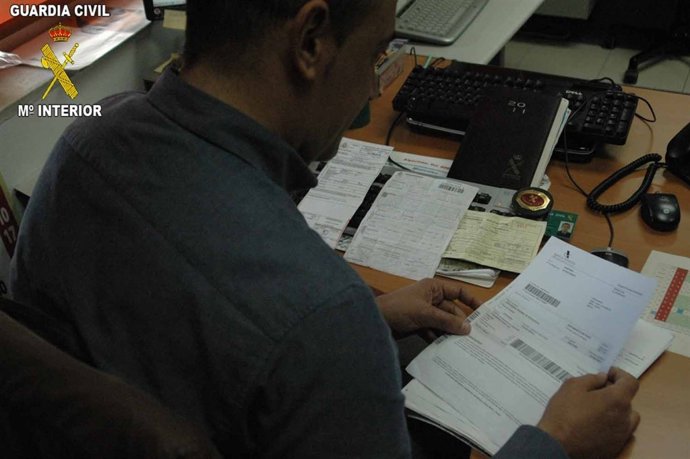 Un Agente De La Guardia Civil Analiza Documentos De La Operacion Detroit