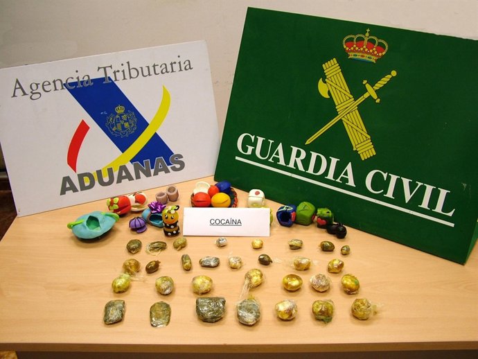 Las Figuras De La Tarta Y La Droga Que Contenían En Su Interior.