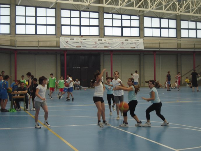 Un grupo de jóvenes jugando un partido de baloncesto