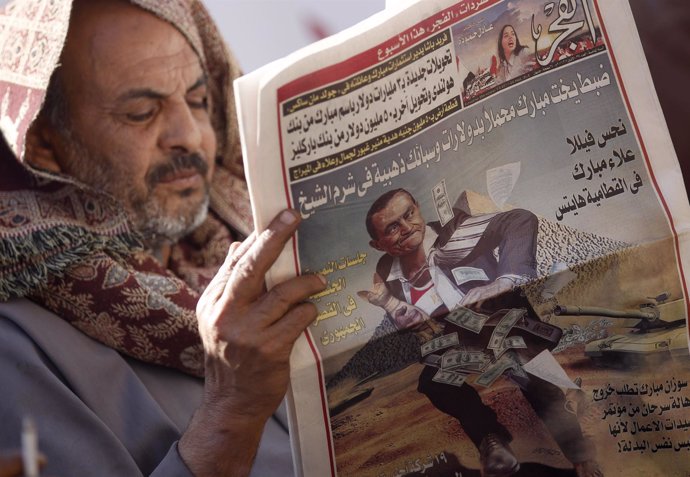 Un hombre leyendo un periódico en la Plaza Tahrir de El Cairo