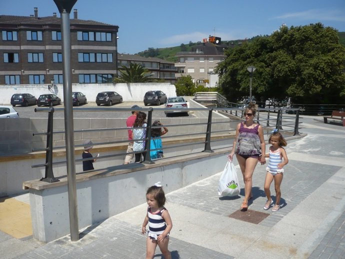 Bañistas En El Paseo Marítimo De Isla. 
