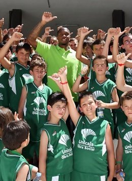 Rowland Posa Junto A Un Grupo De Niños En Su Presentación