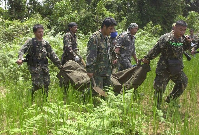 Soldados Filipinos Cargan El Cuerpo De Un Individuo En Medio De La Jungla