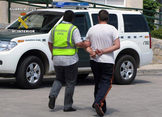 El Detenido Es Conducido Al Vehículo Policial