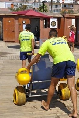 Un Hombre Con Una Silla Para Discapacitados En Una Playa De Malaga