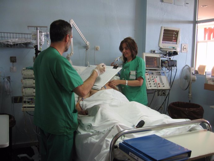 Dos Sanitarios Atienden A Un Paciente En Un Hospital