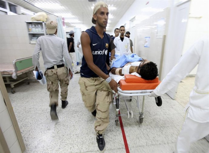 Rebeldes Libios Trasladan A Un Compañero Herido En Combate