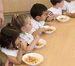 Varios Niños Comen En Un Centro De 0-3 Años.