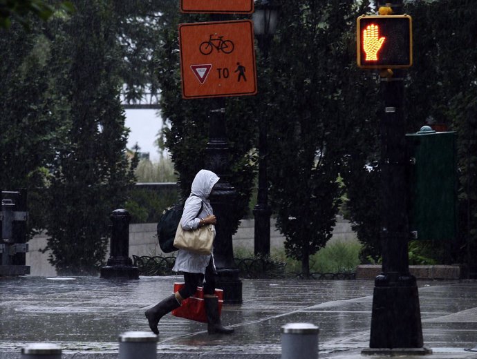 A Pedestrian Walks In The Rain Before The Arrival Of Hurricane Irene At Lower Ma