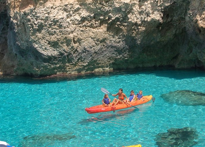 Una Familia Practicando El Kayak De Mar.