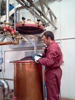 Un Operario Carga Una Caldera Para La Elaboración De Orujo