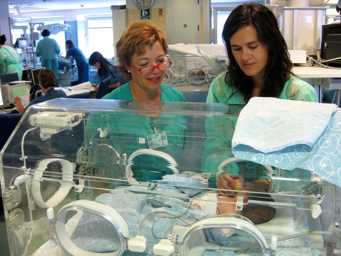 Enfermeras de Neonatología tratan a un bebé prematuro en una incubadora